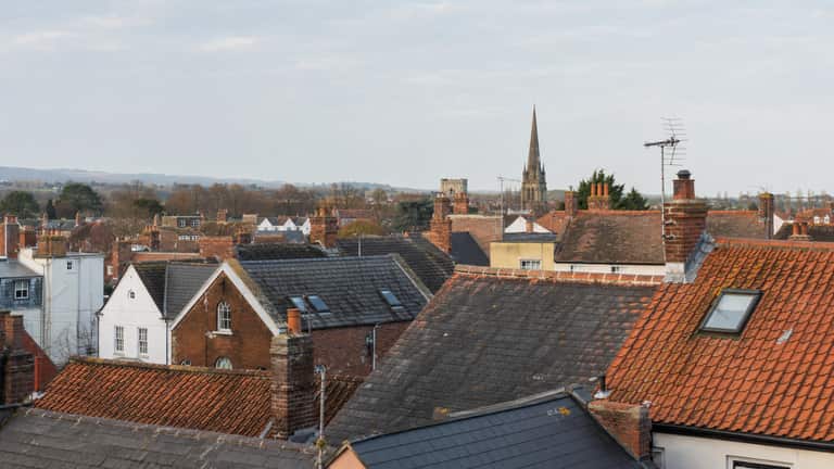 Clay-tiled and slate rooftops with brick chimney stacks across a Somerset market town